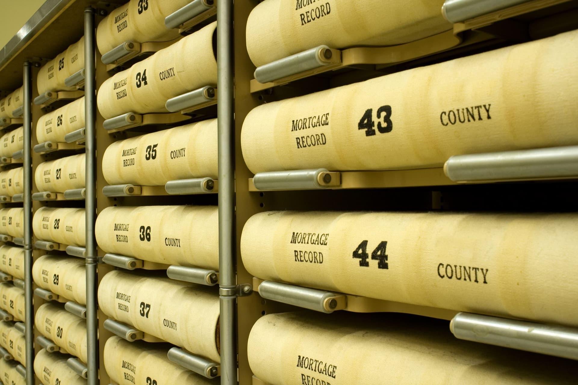 Rows of county mortgage record books on steel shelving