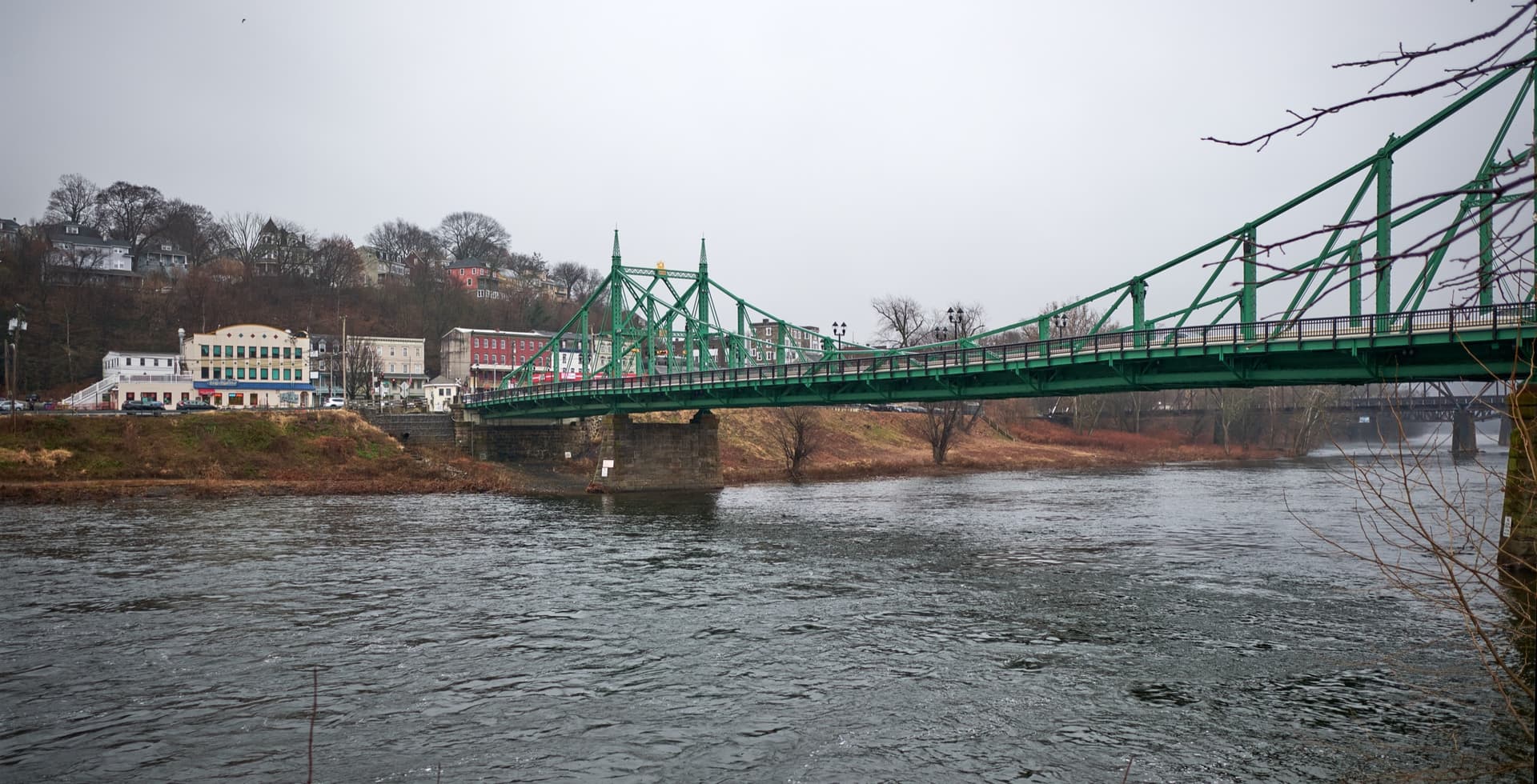 The green Northampton Street bridge spanning the Delaware River at Easton, PA, with College Hill visible in the background