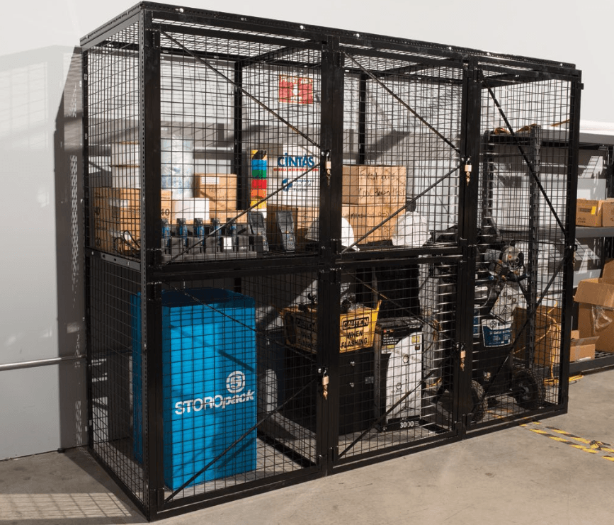 Lockable black wire-mesh tool crib enclosing warehouse inventory.