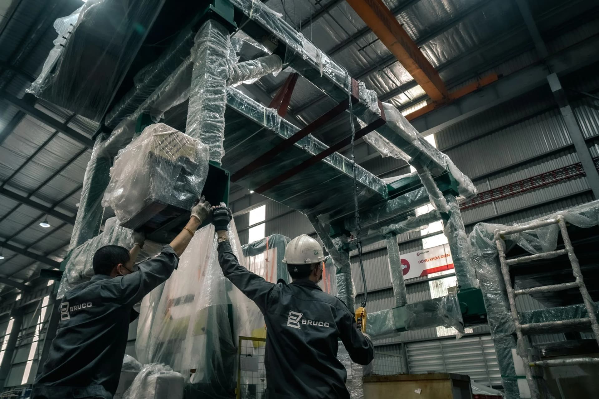 Industrial installation crew positioning equipment inside an operating facility