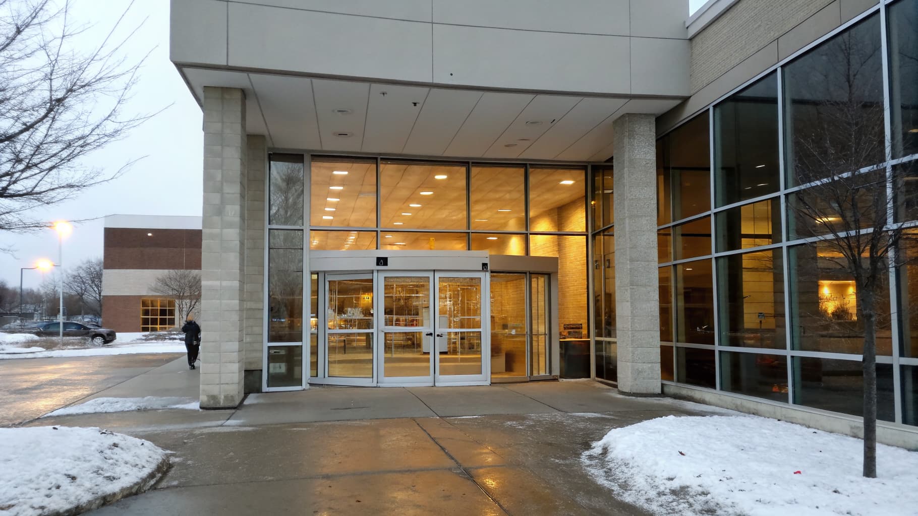 The same entrance enclosed by a modern glass vestibule, warm and sealed
